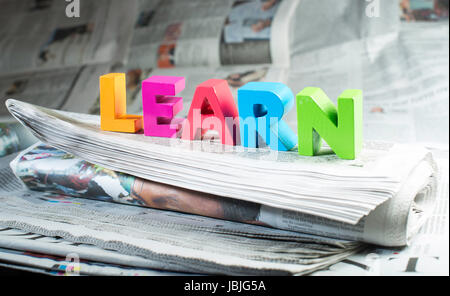 Parola imparare sul giornale. Lettere di legno Foto Stock
