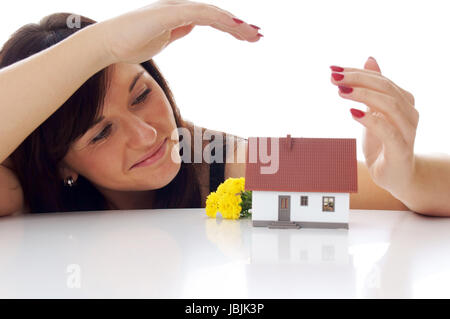 Donna con un po' di casa Foto Stock