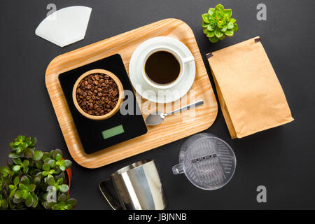 Fagioli arrosto sulla bilancia con tazza di caffè nel vassoio Foto Stock