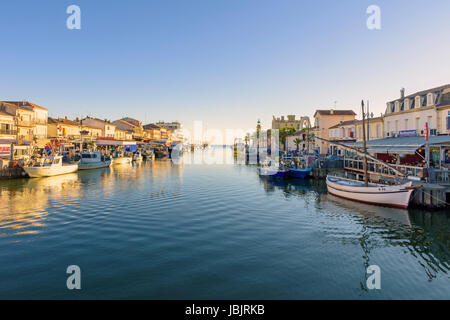 Le Grau-du-Roi barca da pesca foderato canal e la città al tramonto, Le Grau-du-Roi, Gard, Francia Foto Stock