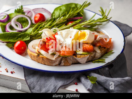 Uovo poached salmone e toast con verdure. Uovo sodo benedetto in stile rustico. Foto Stock