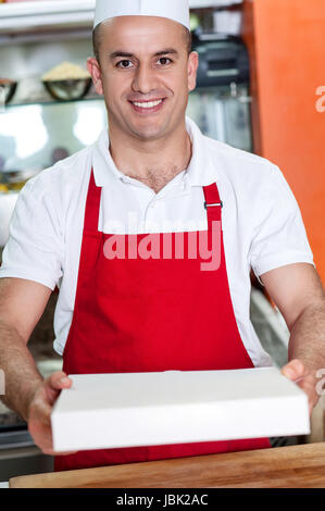 Giovane maschio chef consegna pizza Foto Stock