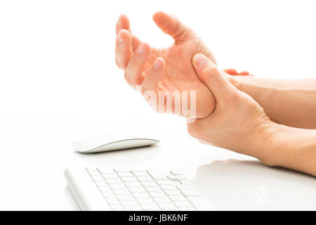 Troppo lavoro - affetti da una sindrome del tunnel carpale - giovane azienda il proprio polso nel dolore a causa di un uso prolungato di tastiera e mouse su sfondo bianco (colore tonica immagine; shallow DOF) Foto Stock