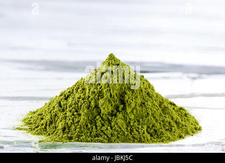 Cumulo di Verde matcha Polvere di tè su bianco weathered sfondo di legno Foto Stock