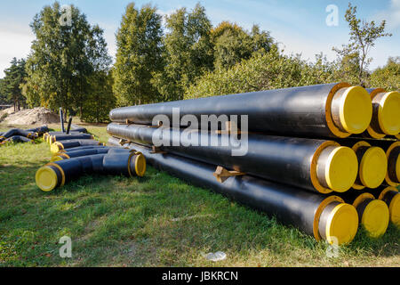 Un mazzetto di nero e giallo costruzione tubi posati a terra Foto Stock