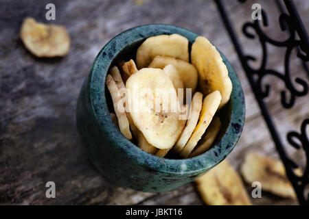 Mangiare sano. Banane essiccate frutta su sfondo di legno Foto Stock