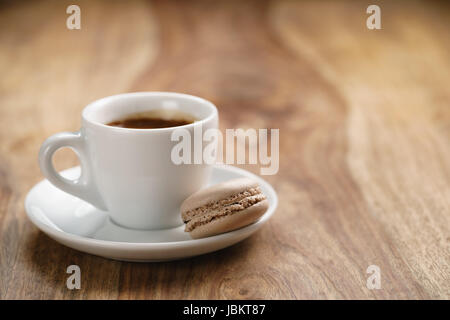 Tazza di caffè espresso fresco con macaron sulla tavola di legno Foto Stock