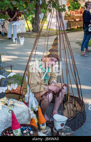 PIESTANY, Slovacchia - 19 Maggio 2017: un misterioso uomo si siede in legno Bird Cage e rende la promozione di prodotti di legno che vendono nei loro stand du Foto Stock