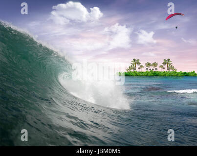 Onda nell'oceano al tramonto con uomo volare nel cielo e isola tropicale in background Foto Stock