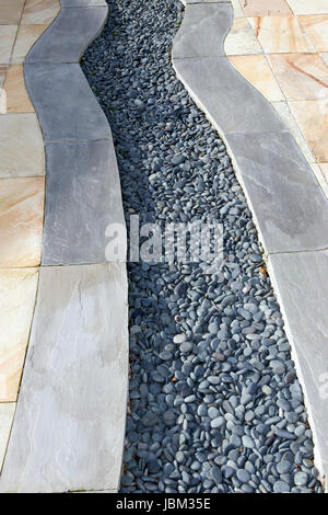 Un patio giardino design con lastre e ciottoli Foto Stock