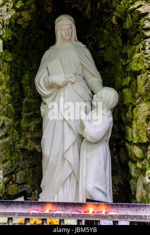 Grotta con le statue della Vergine Maria e il Bambino Gesù, con candele accese, all'Tobarnalt Pozzo santo, nella contea di Sligo, Irlanda Foto Stock