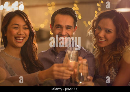 Ritratto sorridente amici tostatura di bicchieri di vino Foto Stock