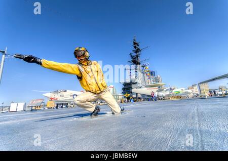 Una statua di un ponte di volo direttore, catapult officer di velivoli di segnalazione in posizione sulla dritta catapulta, in preparazione per il lancio sulla storica USS Midway Museum di San Diego, California, Stati Uniti d'America Foto Stock