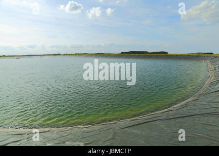 Serbatoio agricolo, uomo, approvvigionamento di acqua per l'agricoltura, Norfolk, Inghilterra, Regno Unito, ritagliare bacini irrigui Foto Stock