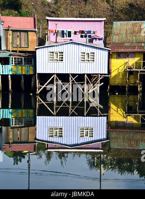 Case Palafitos distintivo sono esempi di architettura Chilote. Le grandi case sono situate sulle rive del fiume Gamboa e il canale Lemuy. Essi sono supportati da pezzi di legno spessi annegata nel fondo dell'oceano e coperte di tetti in piastrella. Con la bassa marea, è possibile vedere dove la struttura di supporto ancore nel pavimento dell'oceano; ad alta marea, le case sembrano galleggiare. Foto Stock