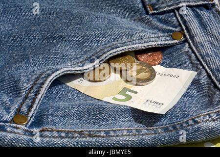 Il denaro nella tasca di un paio di jeans Foto Stock