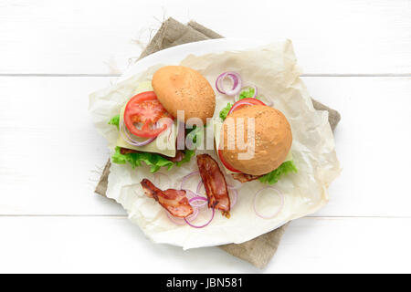 Vista dall'alto di due hamburger serviti sulla carta da forno su bianco tavolo rustico Foto Stock