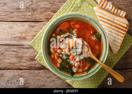 Zuppa di pomodoro con fagioli, spinaci e parmigiano vicino sul tavolo. vista orizzontale dal di sopra Foto Stock