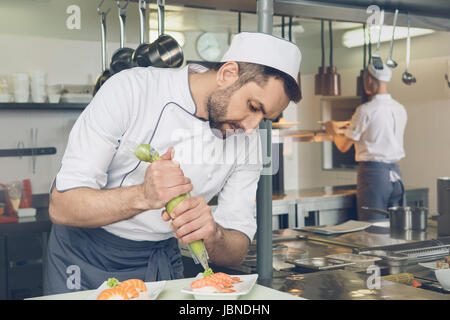 L'uomo ristorante giapponese cucina dello chef in cucina Foto Stock