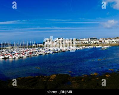 Concarneau's Port de Plaisance come si vede dalla vecchia città fortificata con case in background. Profondo blu dell'acqua. Azzurro cielo. Concarneau, Francia. Foto Stock