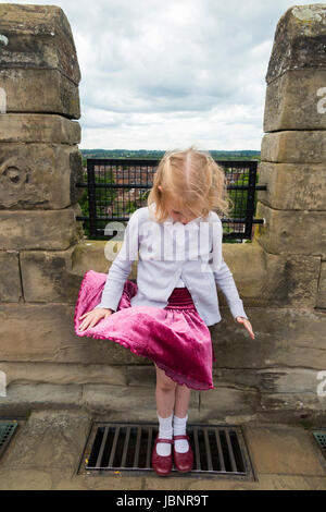 Ragazza / bambini / Kids / bambino / kid giocare in up-progetto di aria / il vento che soffia in cima ragazzo torre, il castello di Warwick nel Warwickshire, Regno Unito. (88) Foto Stock