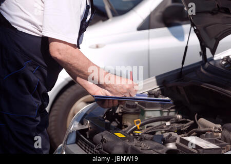 Auto controllo meccanico auto a motore e la scrittura degli appunti Foto Stock