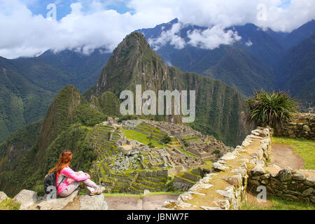 Donna godendo la vista del Machu Picchu cittadella in Perù. In 2007 il Machu Picchu è stata votata come una delle sette meraviglie del mondo. Foto Stock