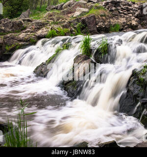 Vista ingrandita della piccola cascata sul fiume Foto Stock