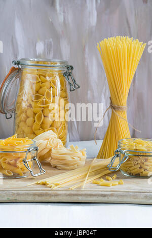 Assortimento di pasta in vasi pm tavolo in legno Foto Stock