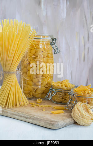 Assortimento di pasta in vasi pm tavolo in legno Foto Stock