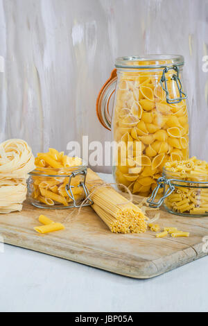 Assortimento di pasta in vasi pm tavolo in legno Foto Stock