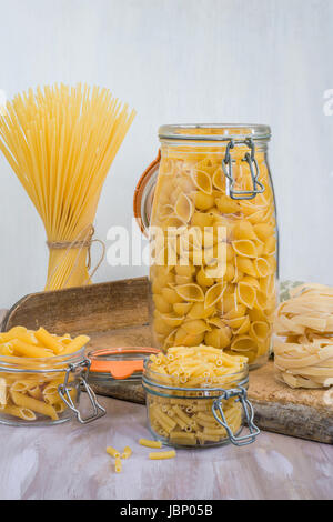 Assortimento di pasta in vasi pm tavolo in legno Foto Stock