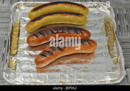 Salsicce alla griglia sulla griglia con la lamina d'argento, close up, macro, frame completo Foto Stock