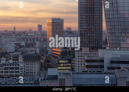 Grattacieli in costruzione nella skyline di Londra contro l'orizzonte al tramonto con il cielo illuminato e nuvole Foto Stock