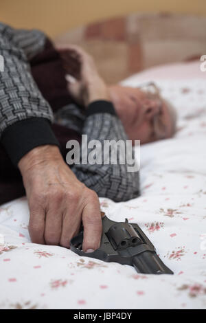 Concetto di suicidio. Vista dettagliata del dead man senior in possesso di una pistola. Foto Stock