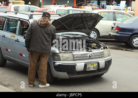 LIMA, Perù - Luglio 21, 2013: Unidentified taxi driver controllando il motore della sua vettura sulla luglio 21, 2013 a Lima in Perù. Foto Stock