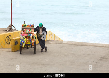 LIMA, Perù - luglio 5, 2013: persona non identificata la lettura di un quotidiano a snack carrello riempito con chip, dolciumi e bevande sulla costa di Barranco il 5 luglio 2013 a Lima in Perù. Foto Stock