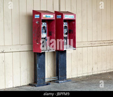 Abbandonato a gettone telefoni pubblici a pagamento con moneta slot di rilascio. Foto Stock