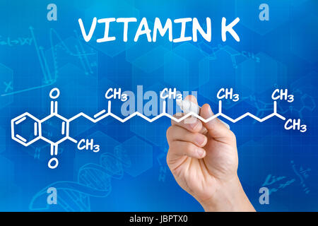 Mano zeichnet chemische Strukturformel von vitamina K Foto Stock