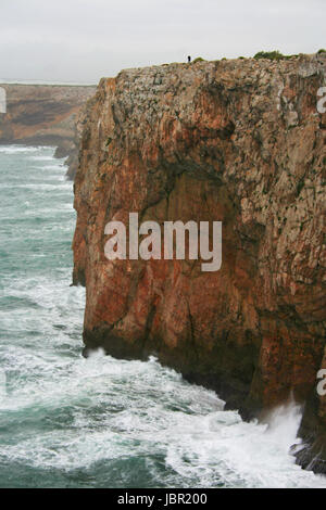 Grave seascape drammatica con il pescatore in Capo San Vicent scogliere, Porrtugal Foto Stock