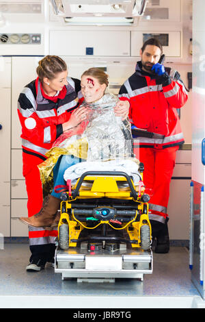 Medico di emergenza e personale paramedico o team di ambulanza aiutando vittima di incidente Foto Stock