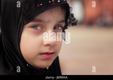 NEW DELHI, India. Maggio 31,2017: un giovane musulmano bambina guarda su come lei insieme con la sua famiglia sit in Jama Masjid.Essi sono qui per rompere il loro giorno lungo digiuno Foto Stock