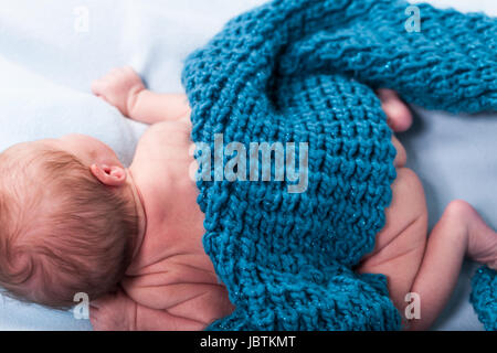 Neugeborenes Baby in einen schal gewickelt schläft nackt als Nahaufnahme Foto Stock