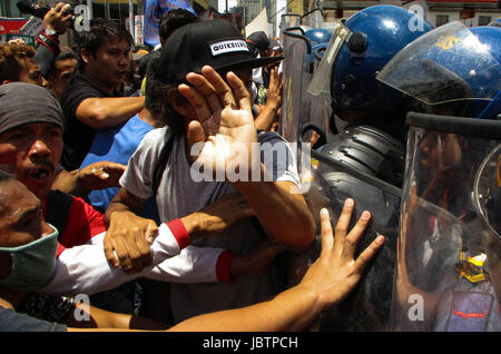 Manila, Filippine. 12 Giugno, 2017. Manifestanti filippino rissa con la polizia che tentano di marzo all'AMBASCIATA DEGLI STATI UNITI durante un rally in coincidenza con il 119° indipendenza filippina giorno a Manila nelle Filippine il lunedì, 12 giugno 2017. (Foto: Richard James M. Mendoza/Pacific Stampa) Credito: PACIFIC PRESS/Alamy Live News Foto Stock