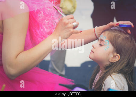 Bambina ottenendo il suo volto dipinto Foto Stock