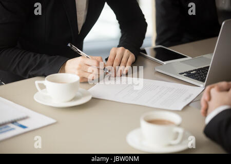 Stretta di mano femmina tenendo pen, circa a firmare la carta ufficiale, mettendo la firma sul documento legale, inchiostro trattativa, immettere concludere il contratto di prestazione di servizi Foto Stock