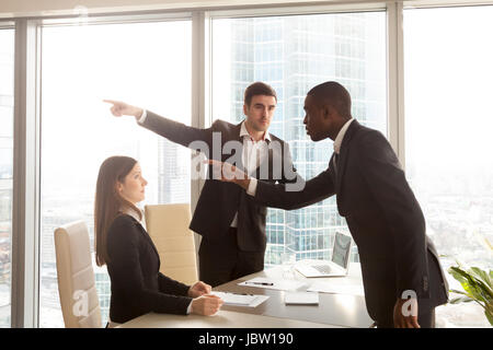 Rude imprenditore nero si comporta in modo insultante impolitely alla riunione, puntando al scioccato white woman, getting cotta per un comportamento inopportuno, bad manne Foto Stock