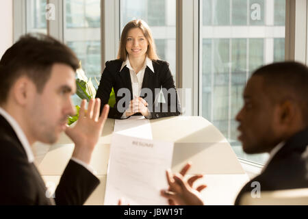 Preoccupati imprenditrice nervoso in attesa del risultato mentre reclutatori revisione di riprendere, rendendo la decisione di assunzione, disoccupati giovani femmine richiedente sperando t Foto Stock