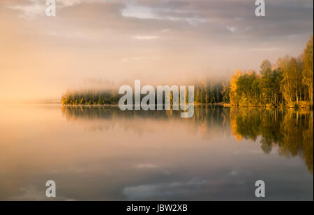 Paesaggio panoramico con il lago e i colori dell'autunno alla luce del mattino Foto Stock