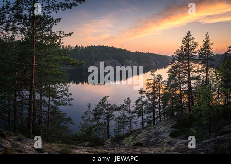 Paesaggio panoramico con il tramonto del sole e del lago alla serata estiva in Finlandia Foto Stock